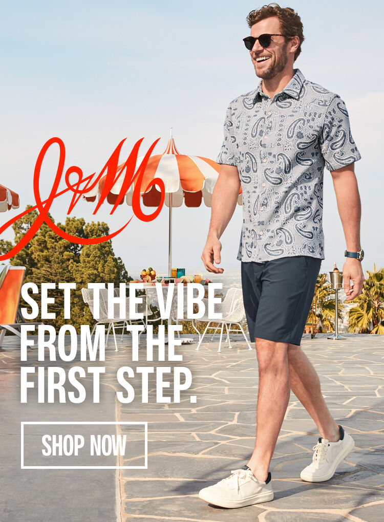 Man dressed in Johnston & Murphy blue patterned polo with navy shorts on, walking on a patio with a red J&M logo and words that read "set the vibe from the step" with a shop now button on the left of the guy.